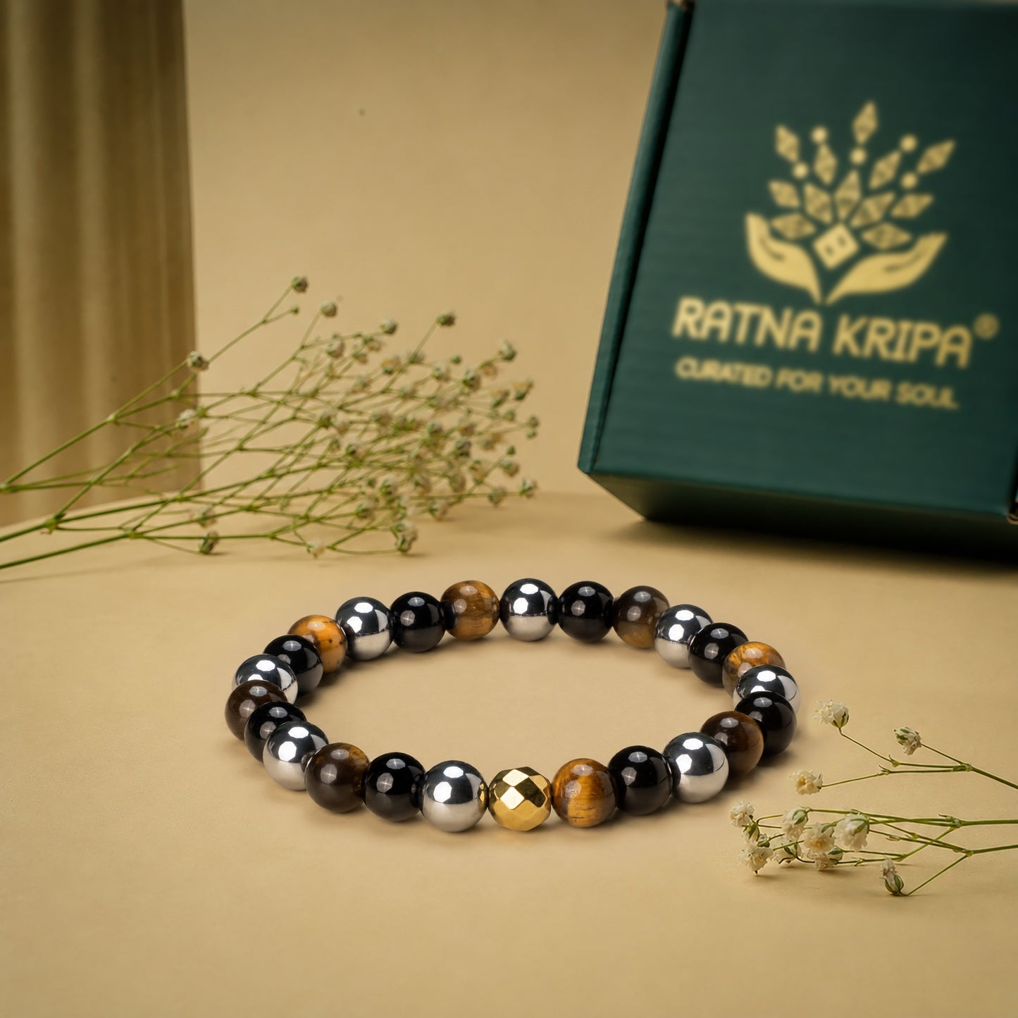 Multicolored beaded bracelet on a beige surface with a 'Ratna Kripa' branded box in the background.
